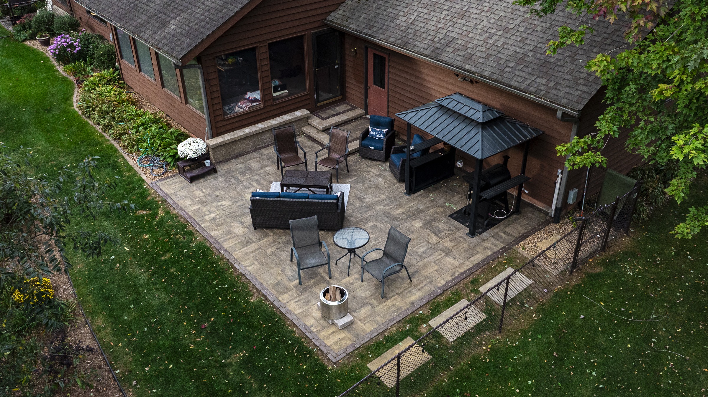 Backyard patio with seating, gazebo, and fire pit