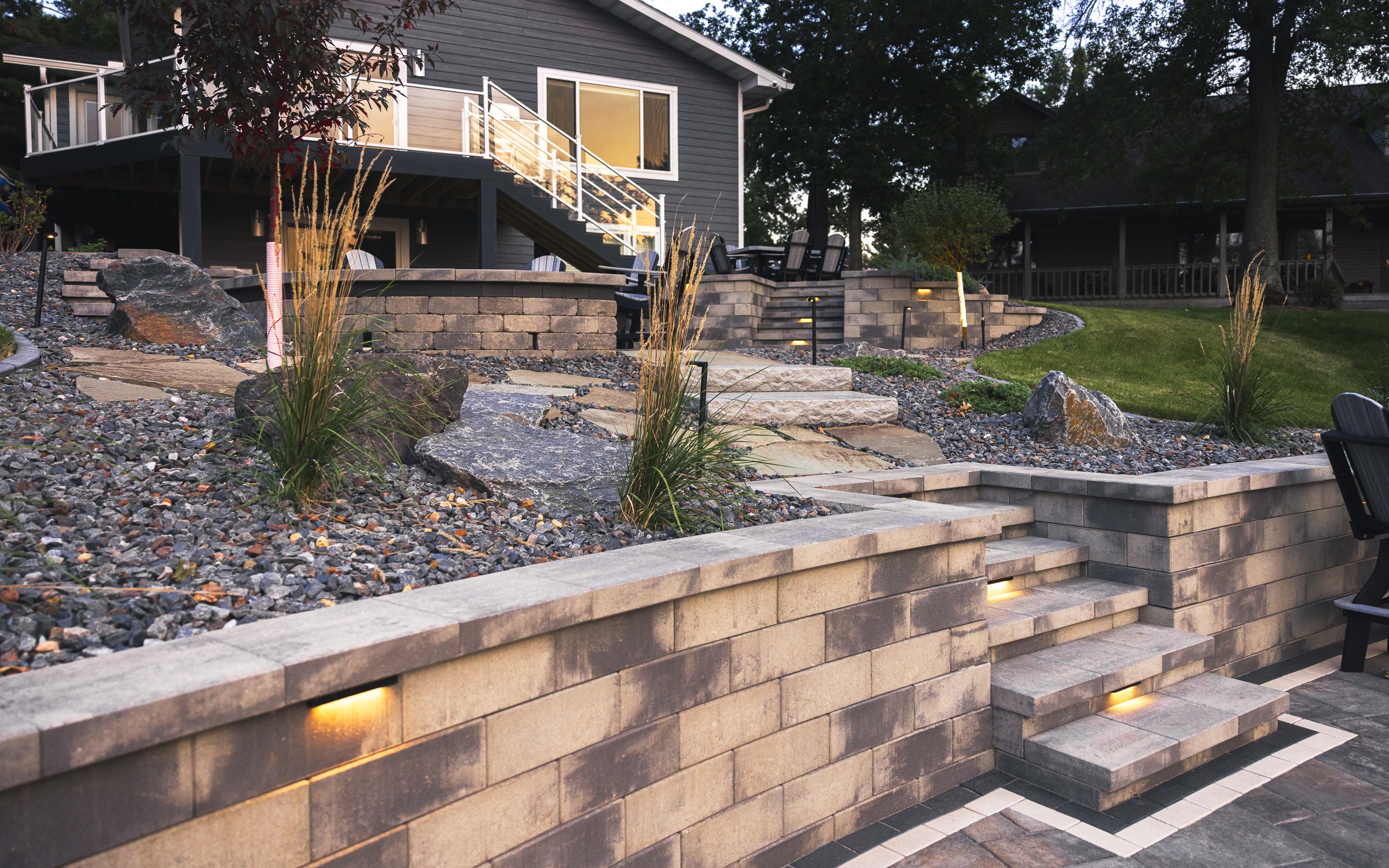 Modern backyard with tiered retaining walls and lighting