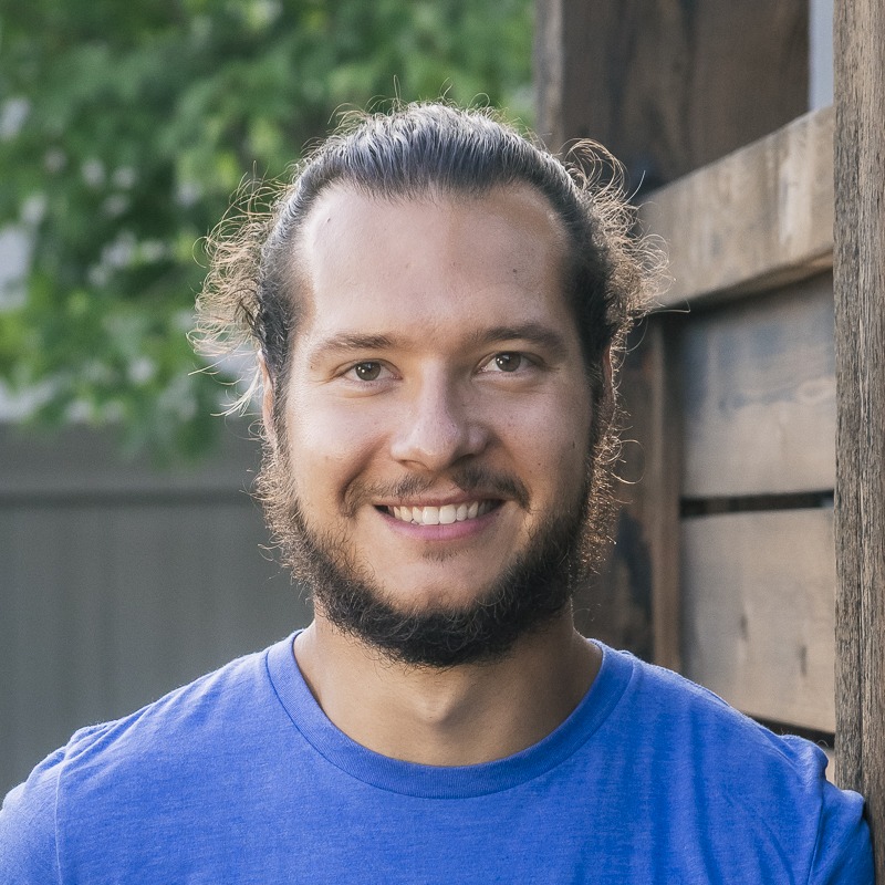 Smiling bearded man in blue shirt outdoors