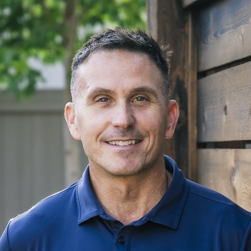 Smiling man in blue polo outdoors