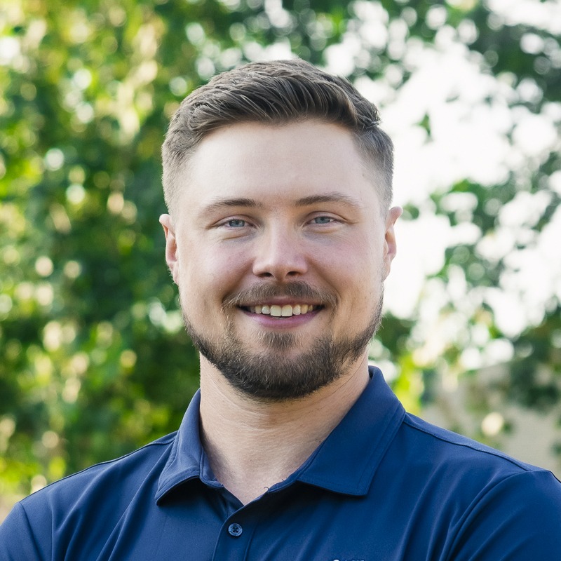 Smiling man in navy polo outdoors