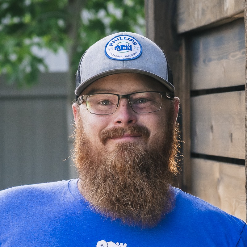 Bearded man wearing glasses and gray baseball cap
