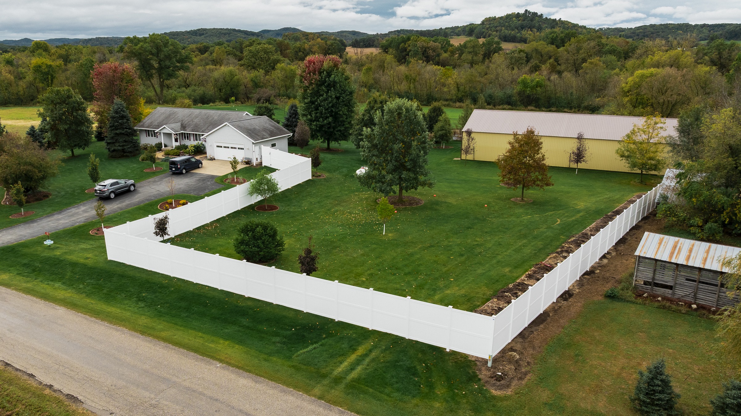 Aerial view of fenced suburban home and yard