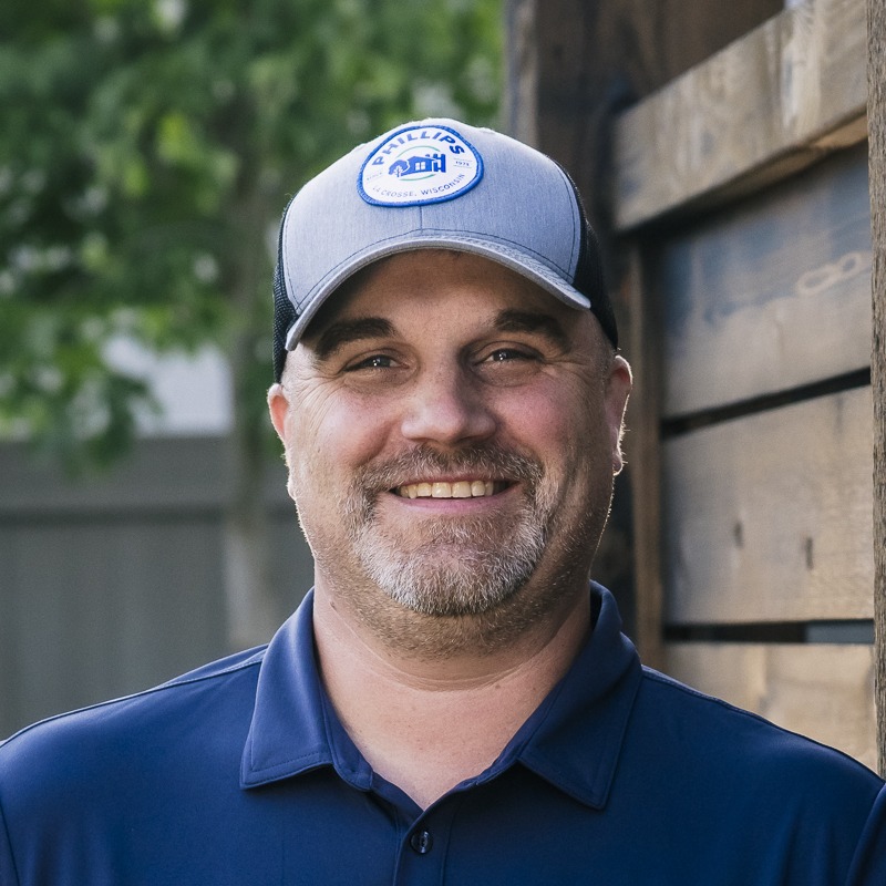 Smiling man in cap and blue polo outdoors