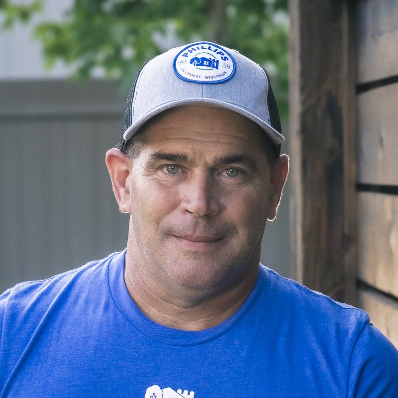 Man in blue shirt and gray cap outdoors