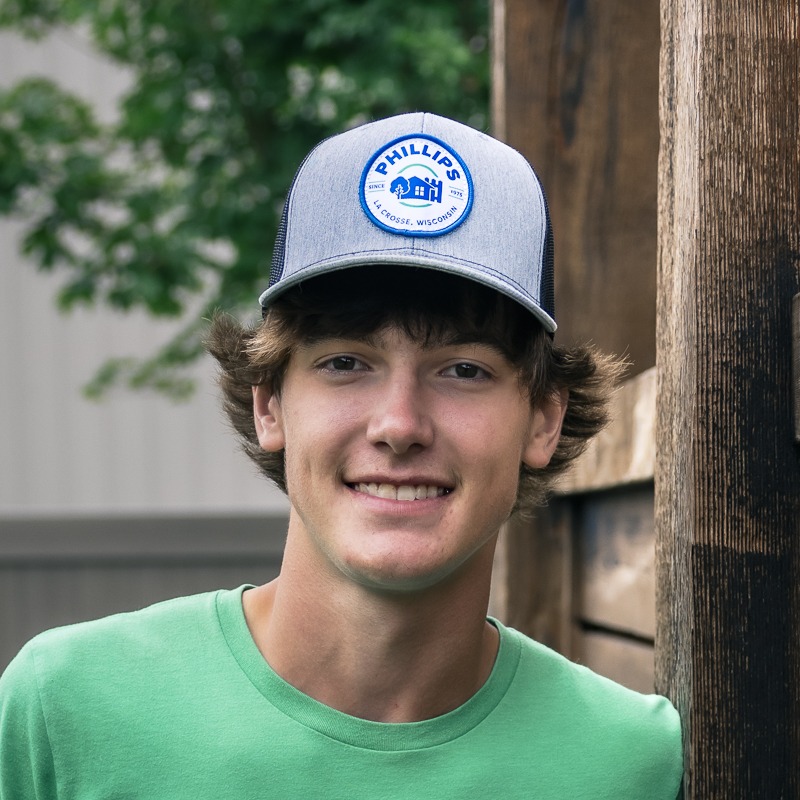 Young man in gray cap smiling outdoors
