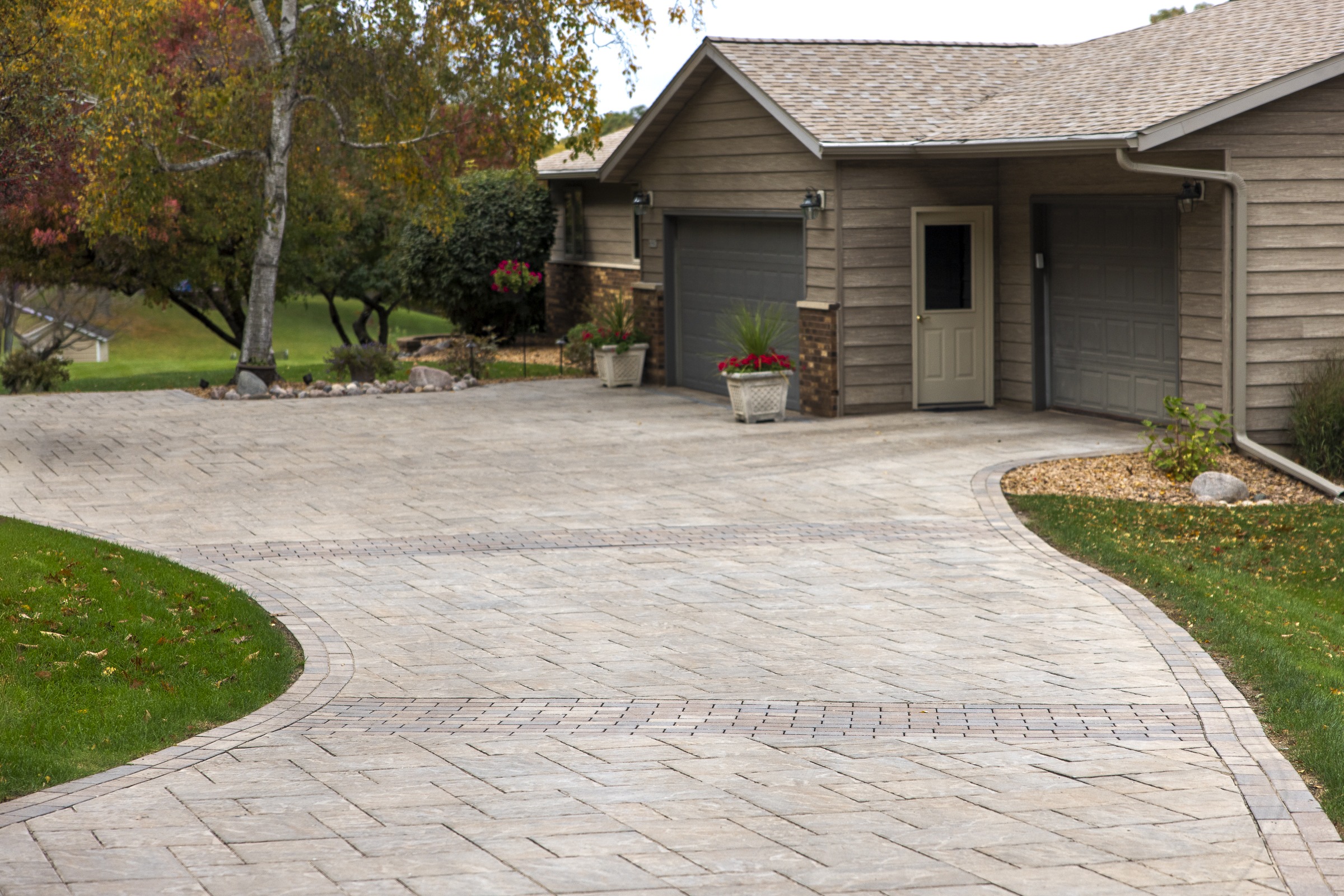 Curved paver driveway leading to two-car garage
