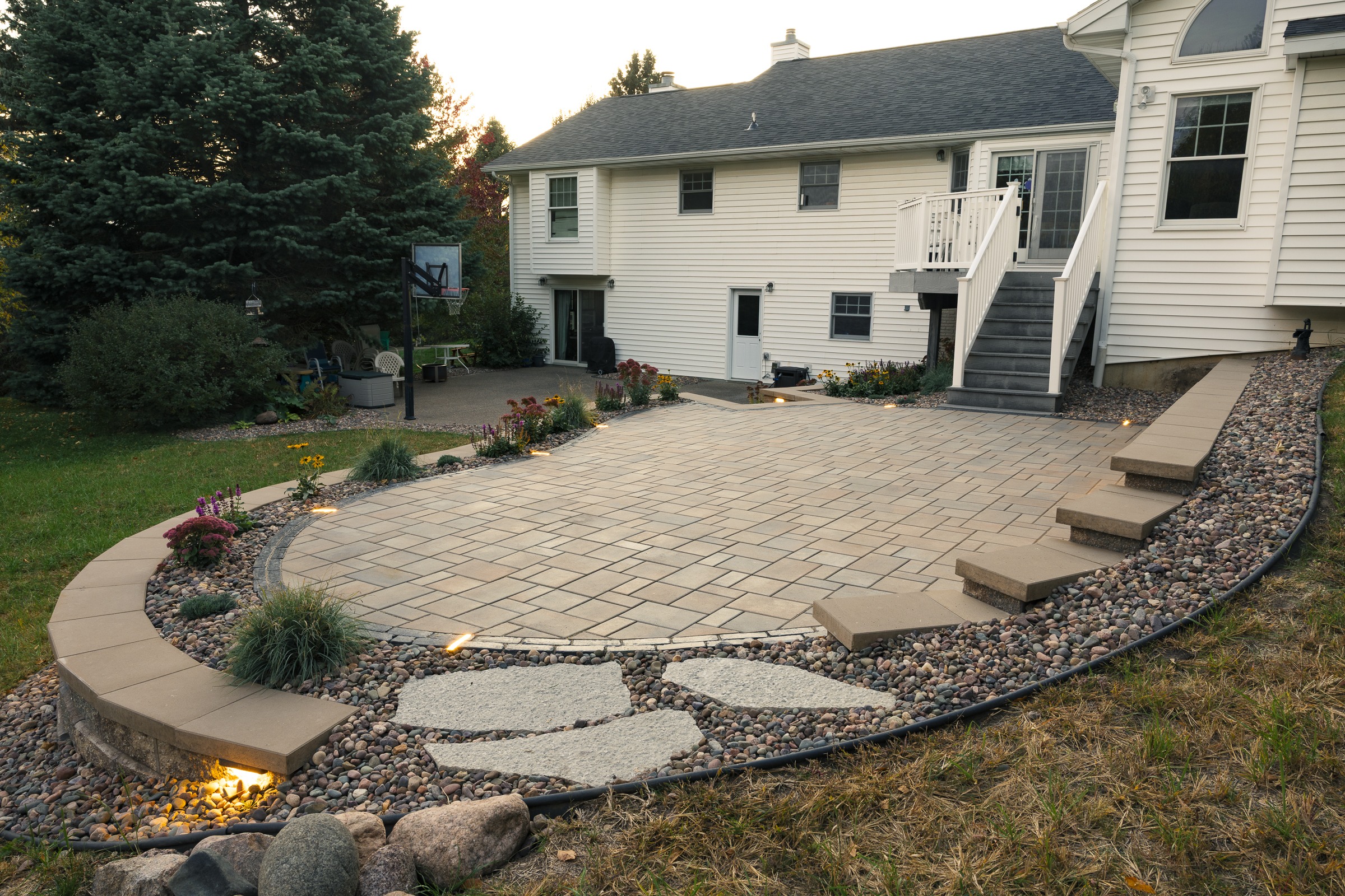 Backyard paver patio with steps and landscape lighting