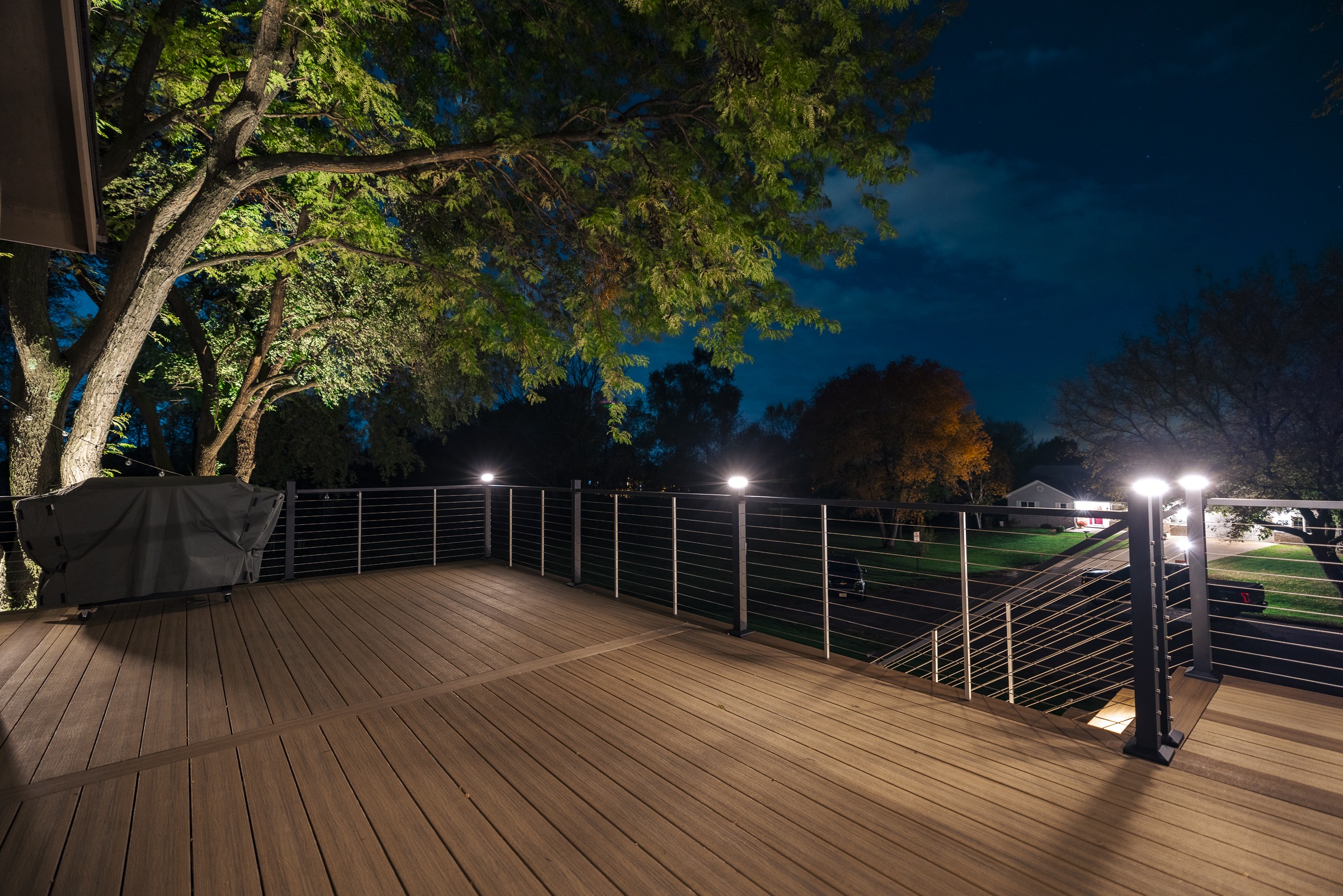 Modern wooden deck with railing lights at night