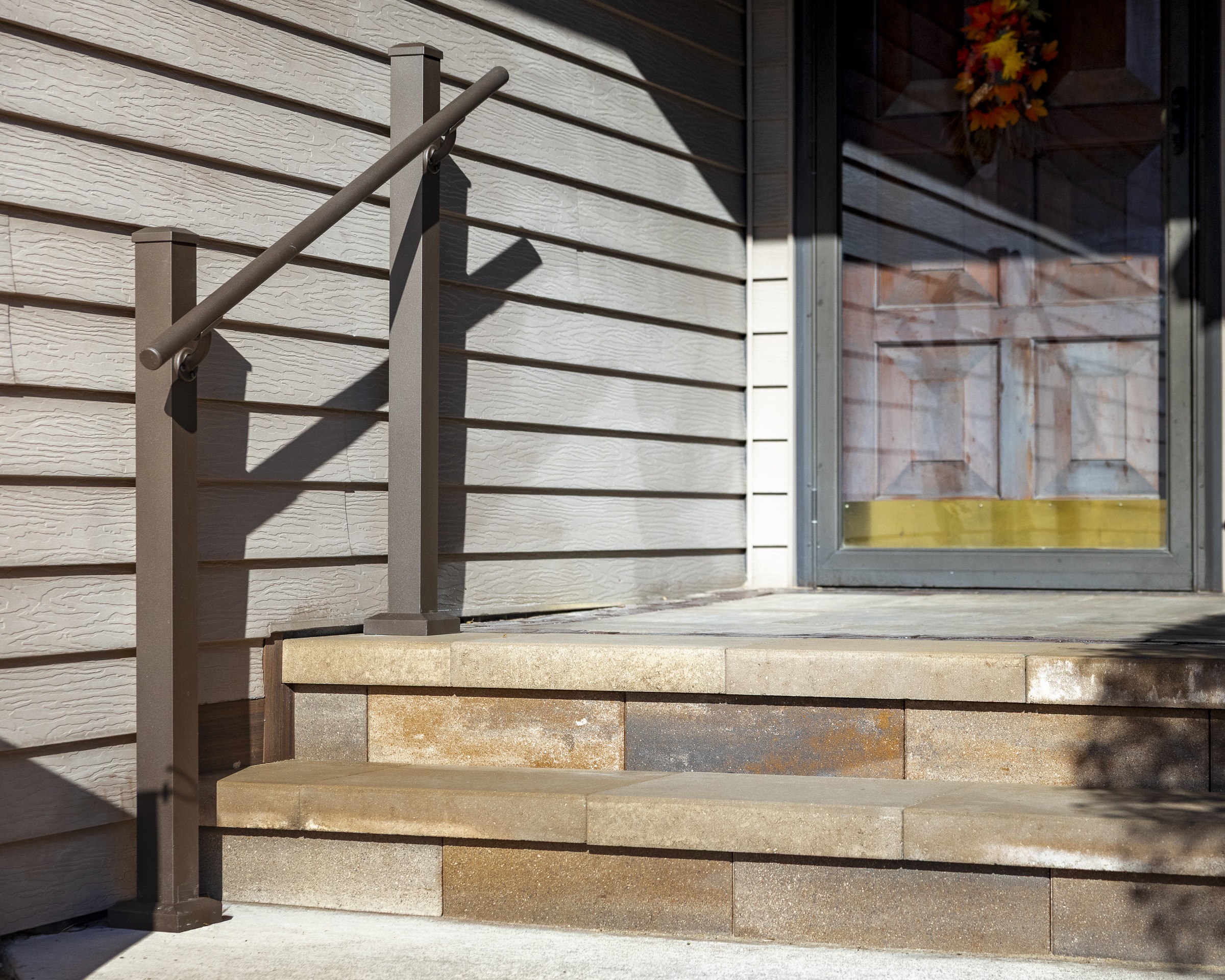 Front porch steps with metal handrail and door