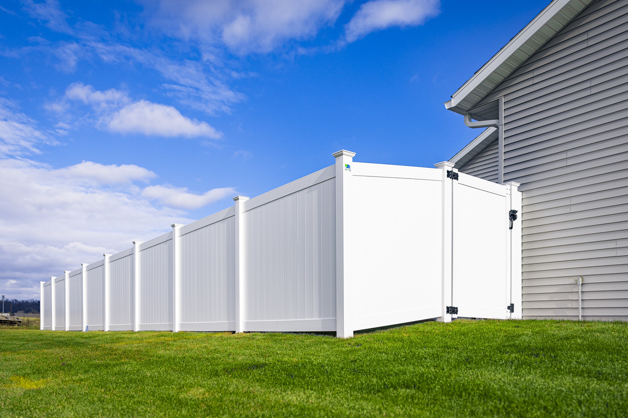 White vinyl privacy fence beside suburban home