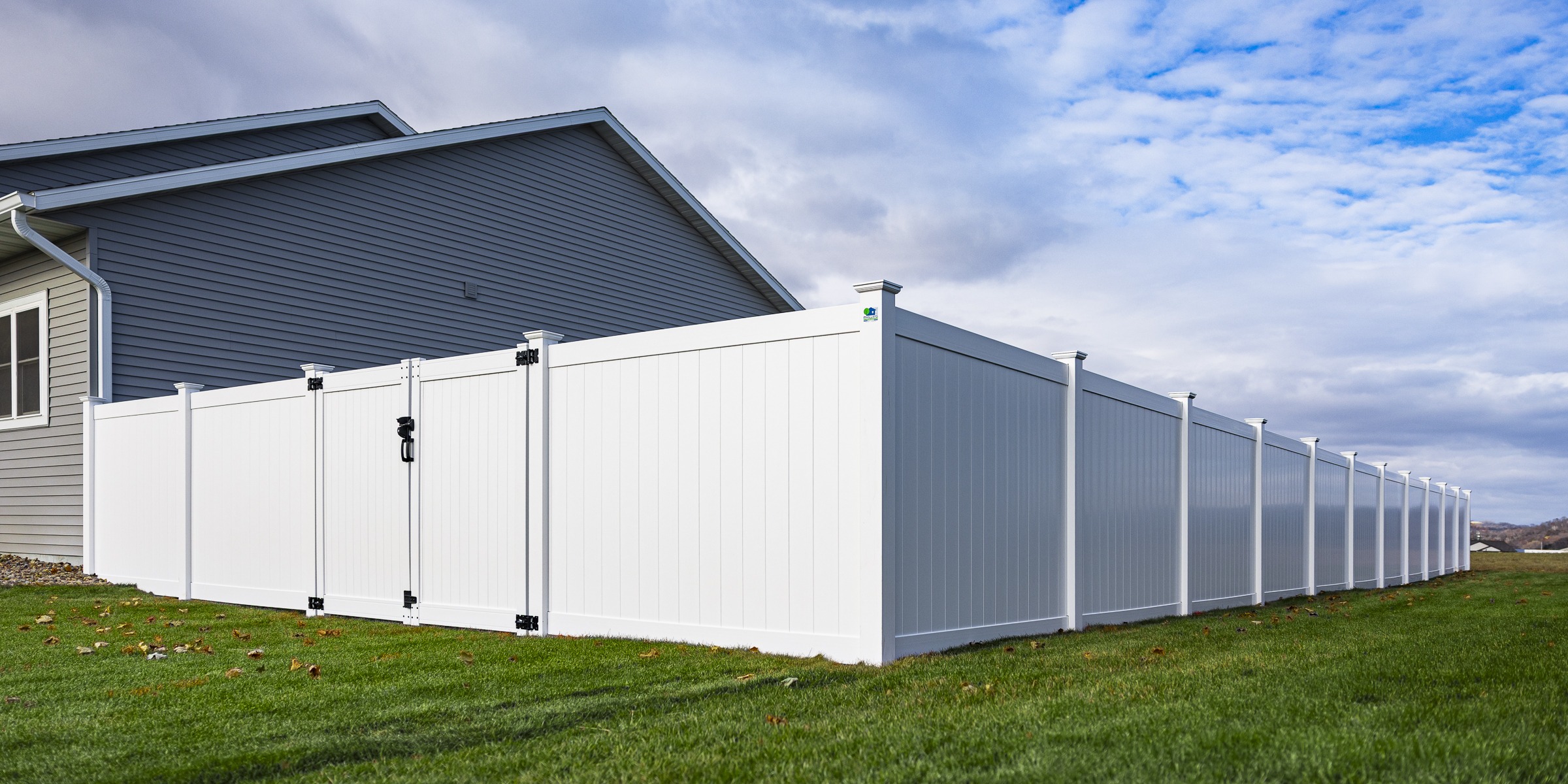 White vinyl privacy fence beside suburban home