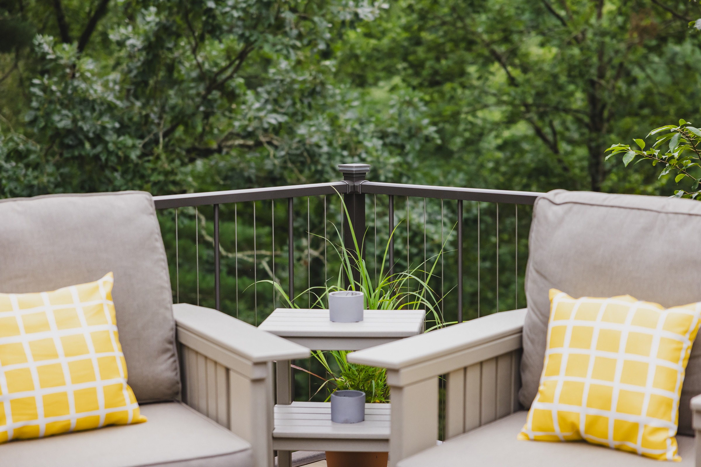 Cozy patio chairs with yellow pillows and forest view