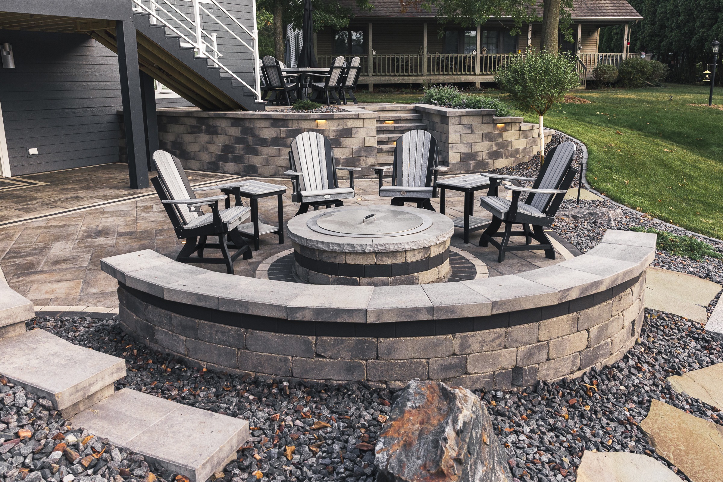 Backyard patio with circular fire pit and chairs