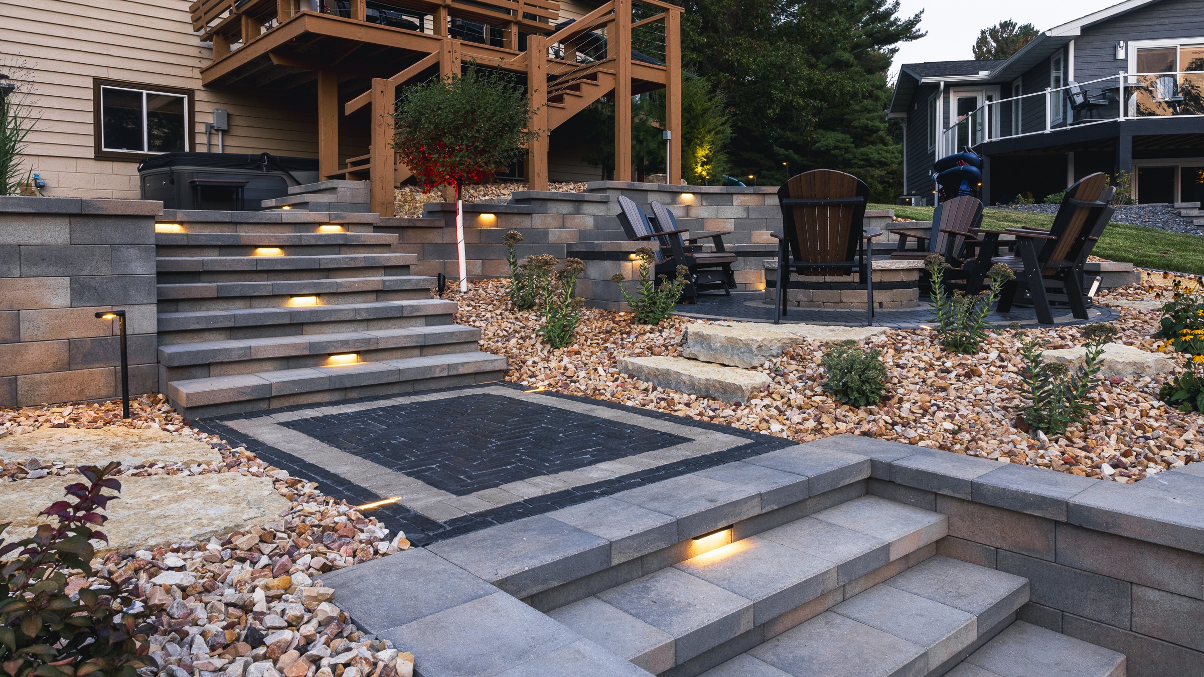 Landscaped backyard patio with lit stone steps