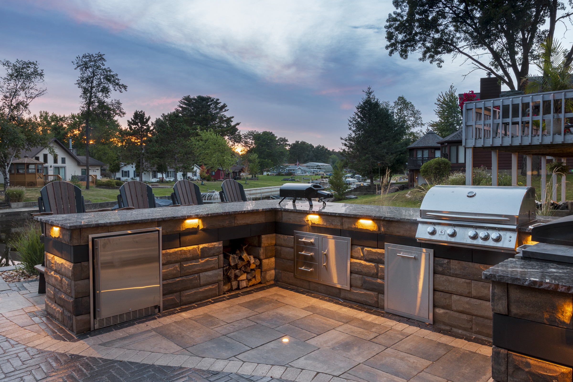 Outdoor kitchen patio with grill at sunset