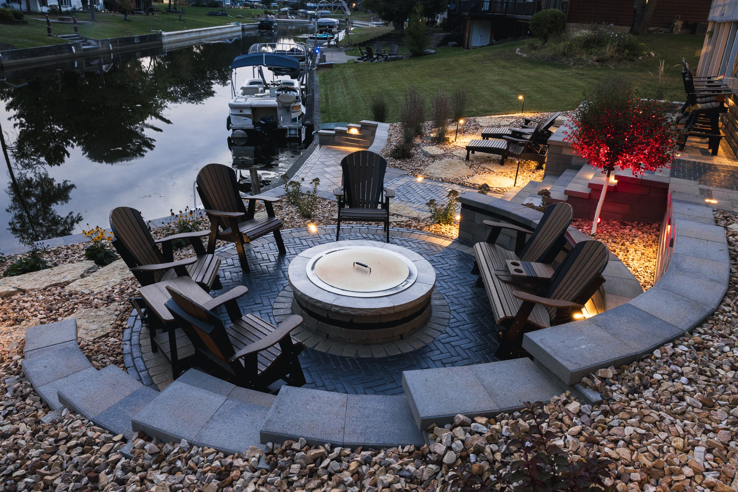 Waterfront patio with fire pit and Adirondack chairs
