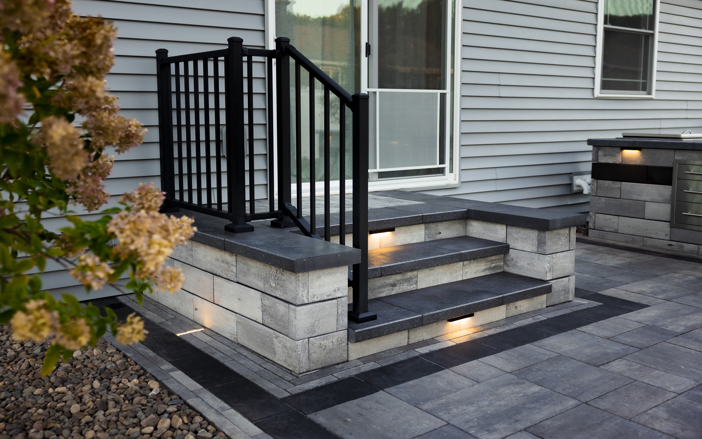 Modern patio steps with black railing and lighting