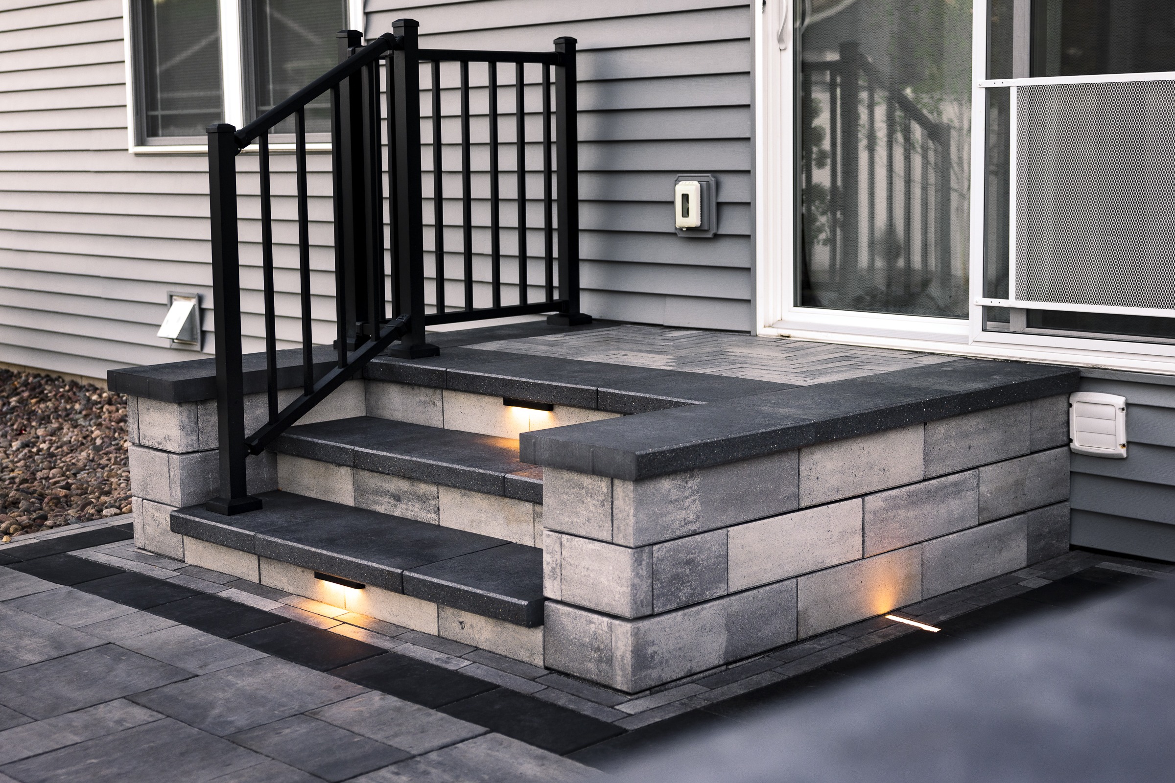 Modern concrete porch steps with black metal railing