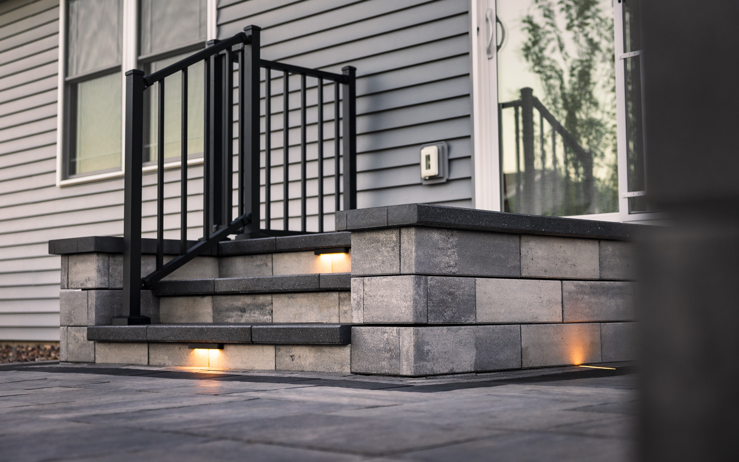 Modern concrete porch steps with black metal railing
