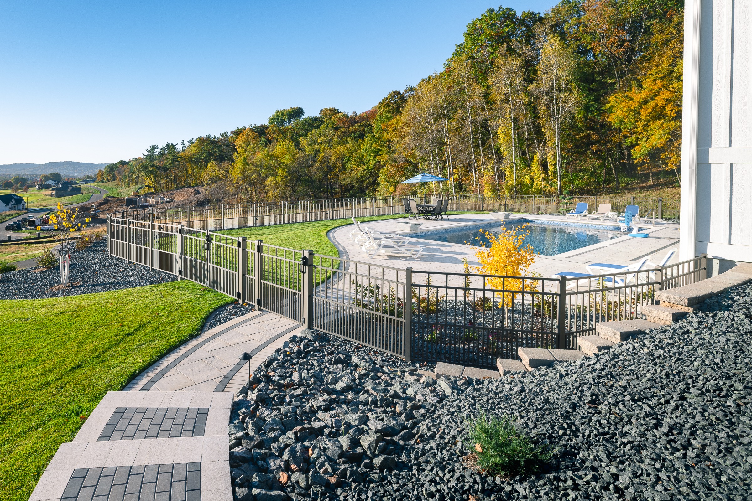 Fenced backyard pool with autumn hillside views