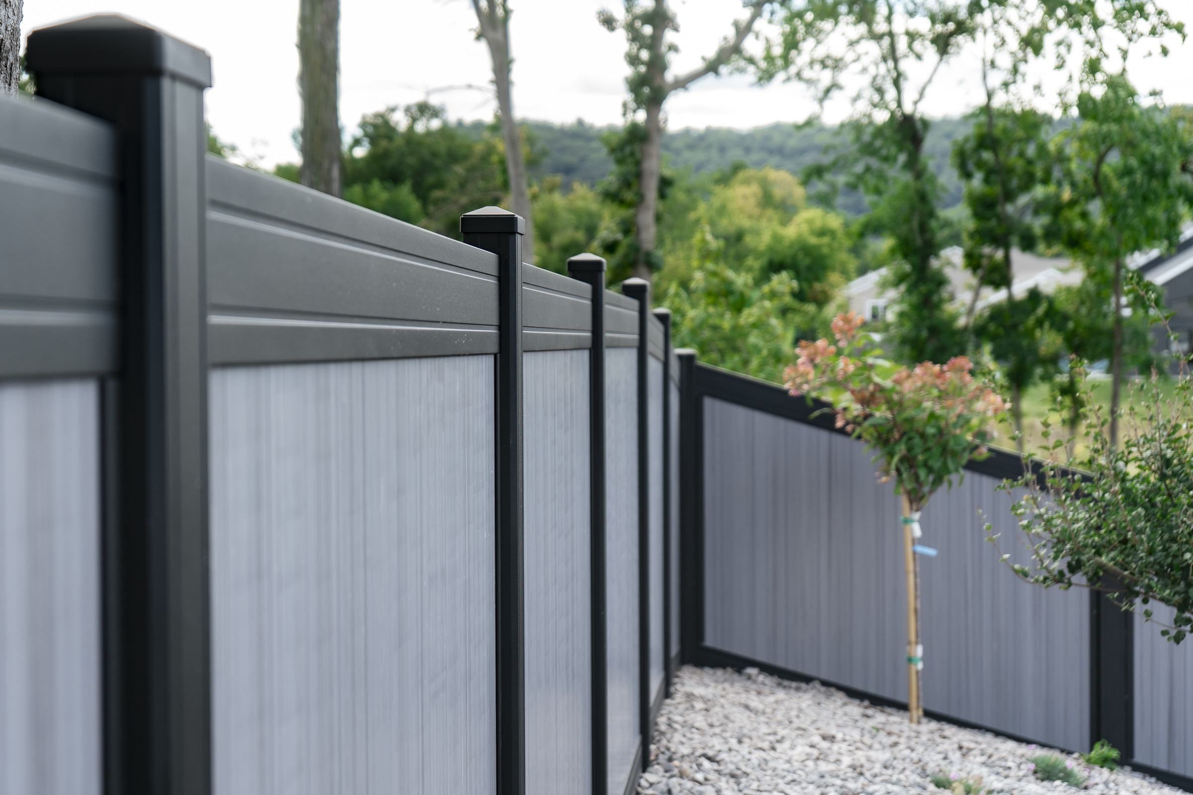 Modern gray vinyl privacy fence in backyard
