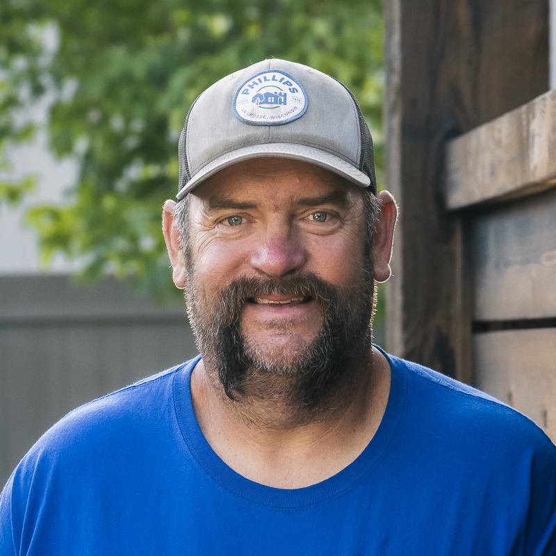 Smiling bearded man in cap outdoors