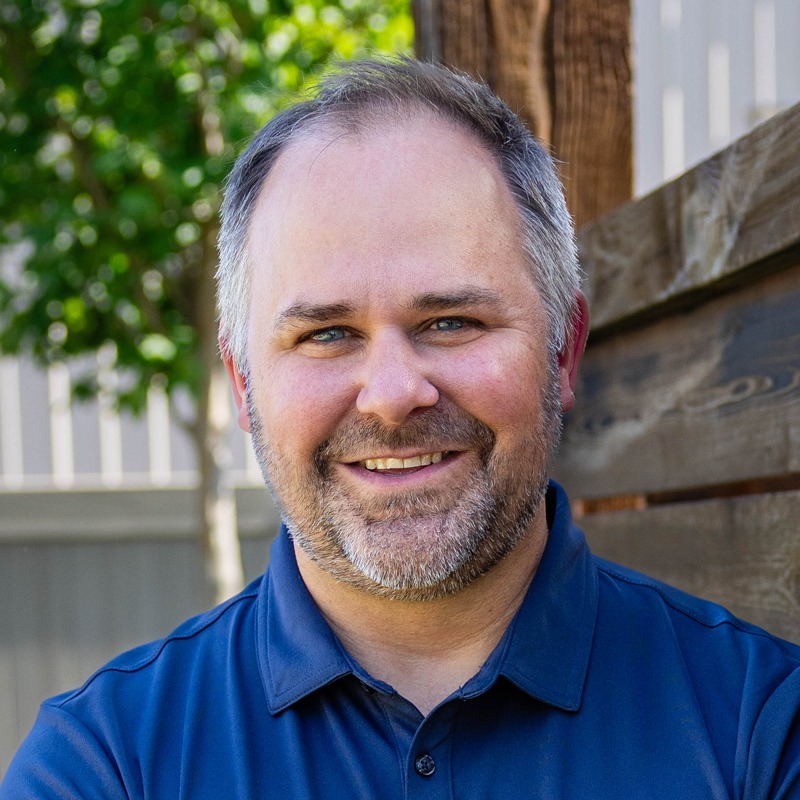 Smiling man in blue polo outdoors