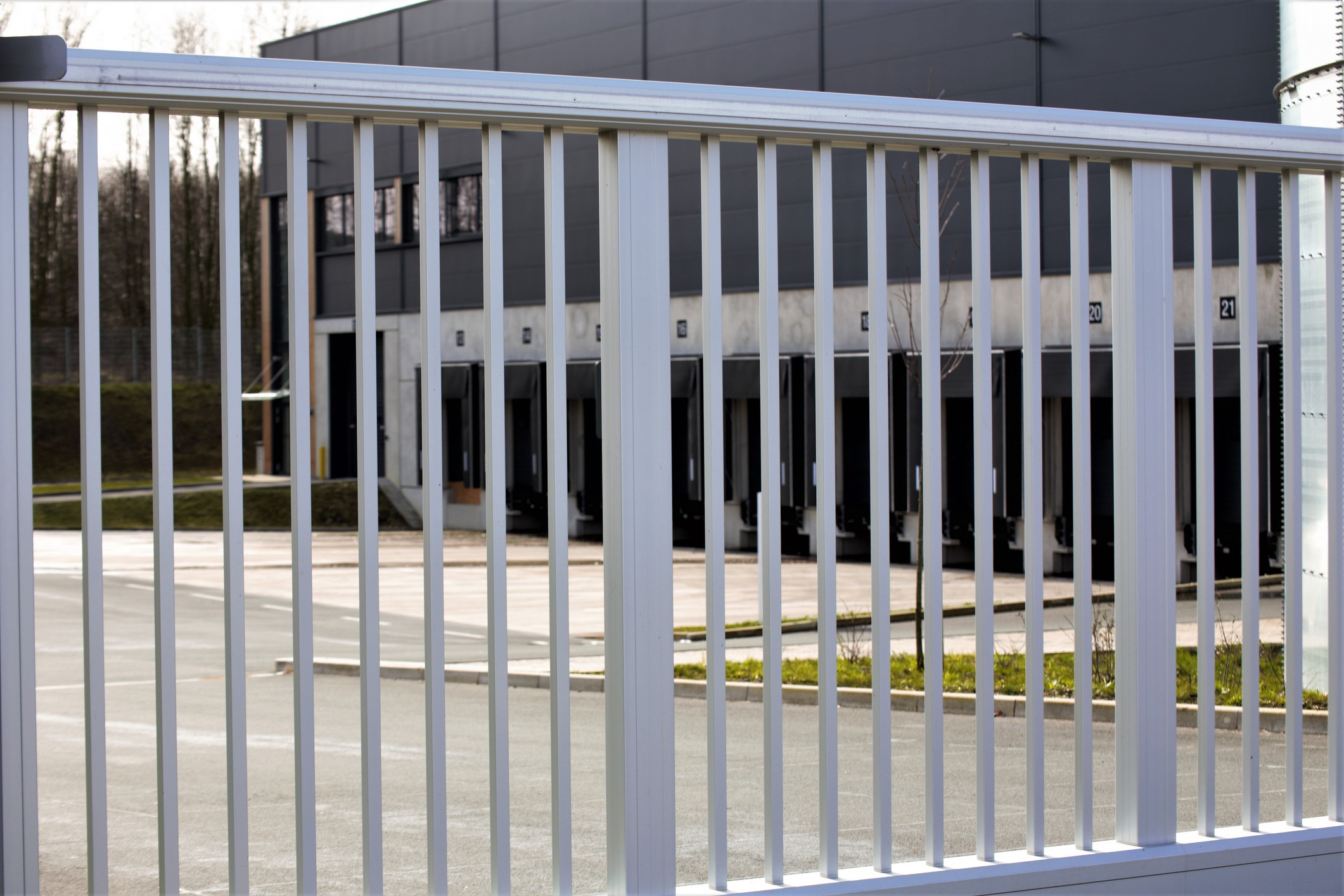 White metal fence in front of warehouse loading docks