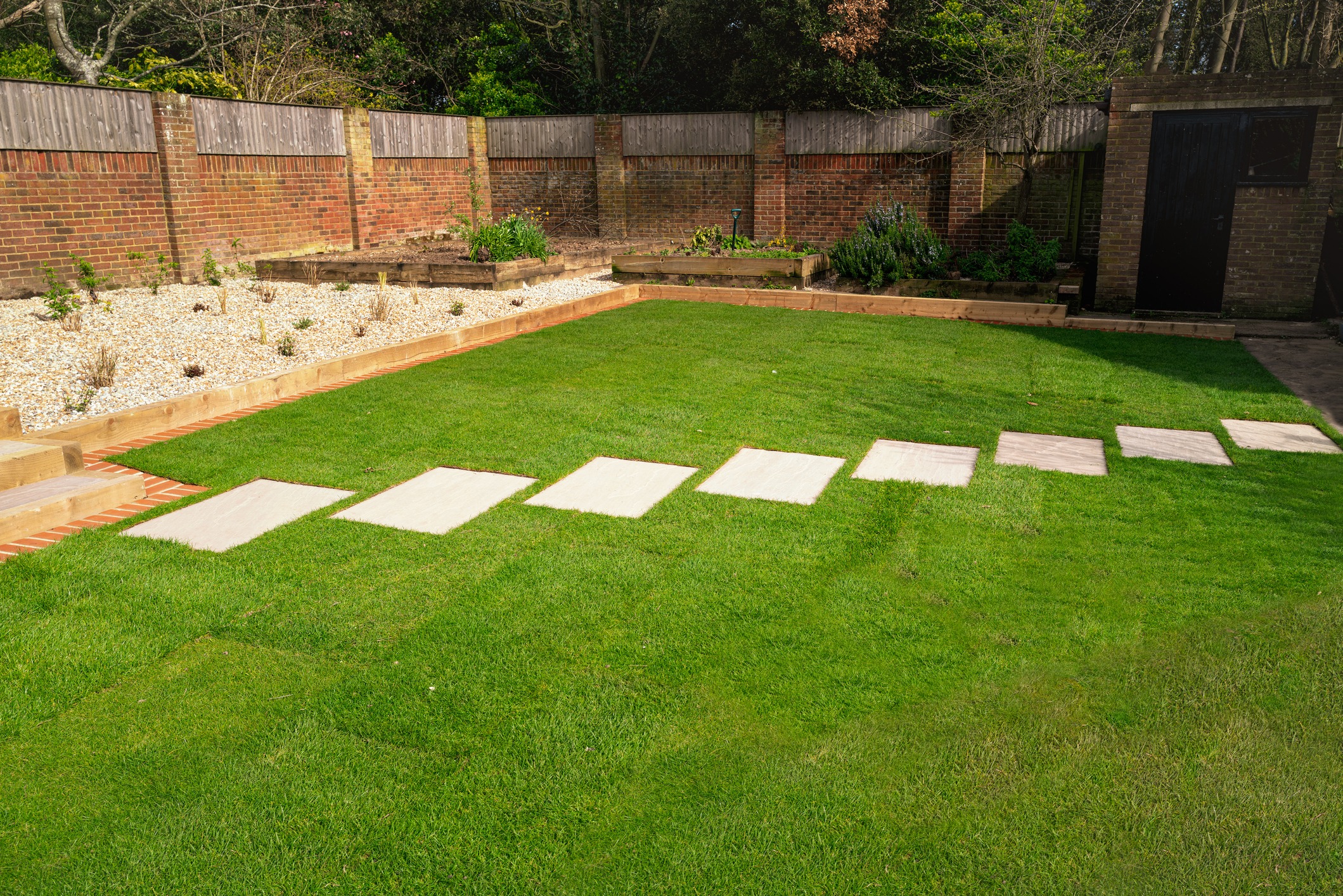 Landscaped backyard with lawn and stepping stones