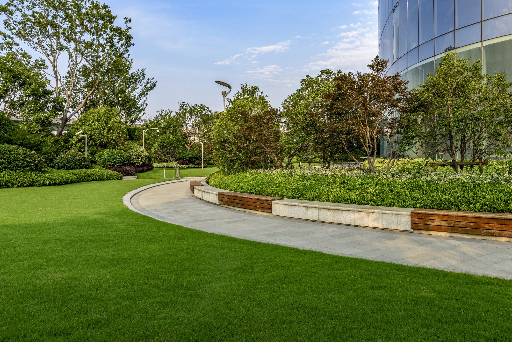 Modern landscaped garden with curved walkway and glass building