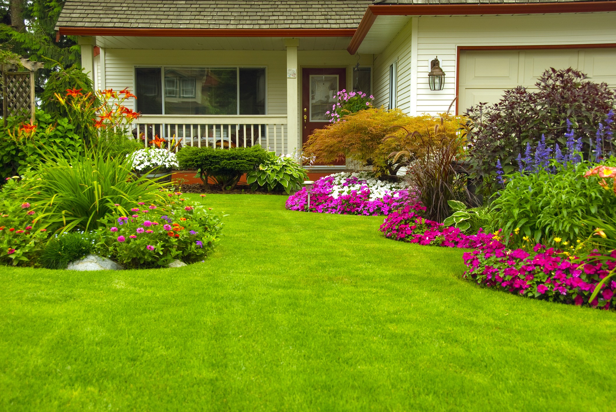 Lush front yard with colorful flowers and porch