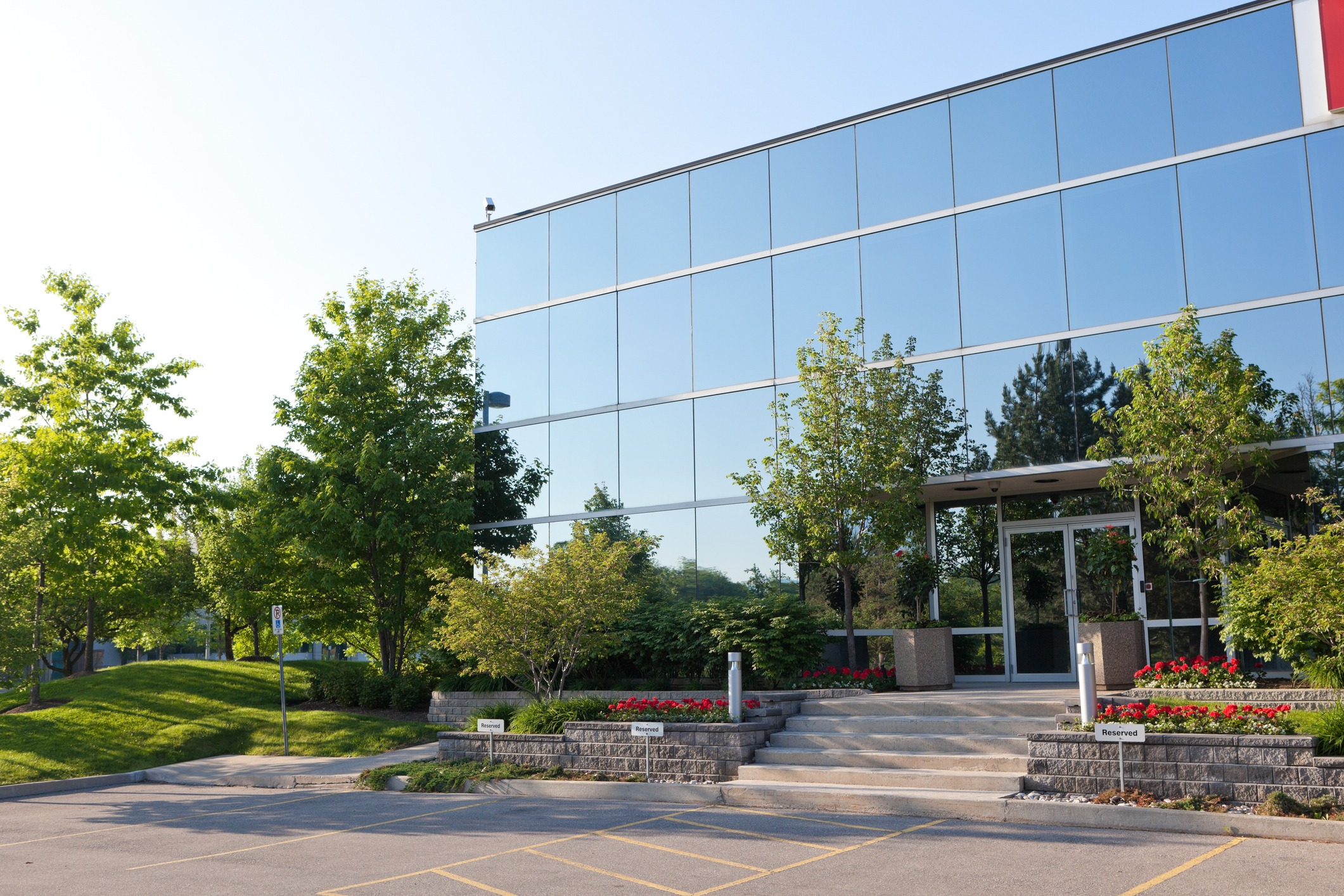 Modern glass office building with landscaped entrance
