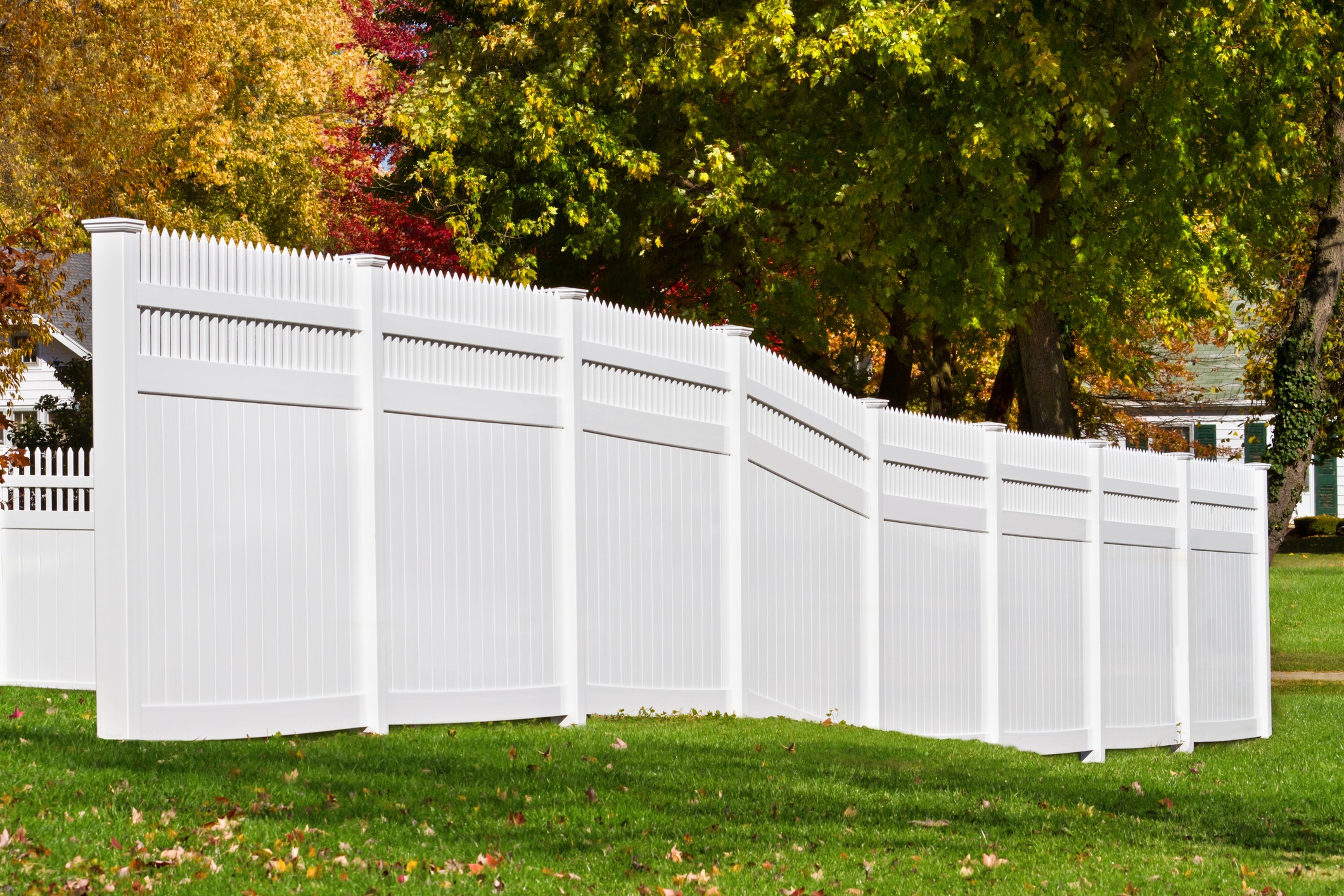 White vinyl privacy fence in suburban backyard