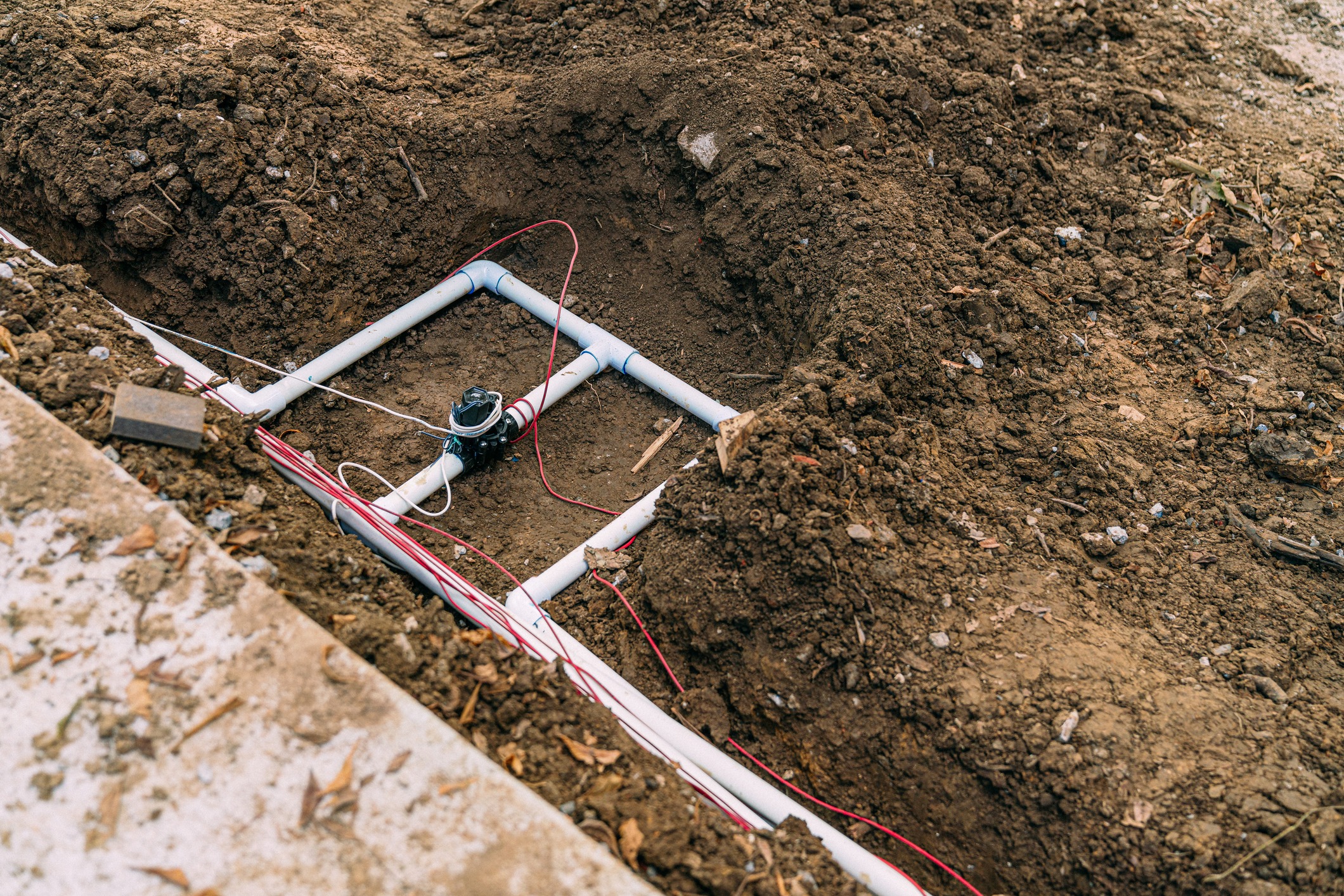 Underground PVC irrigation pipes in dug trench