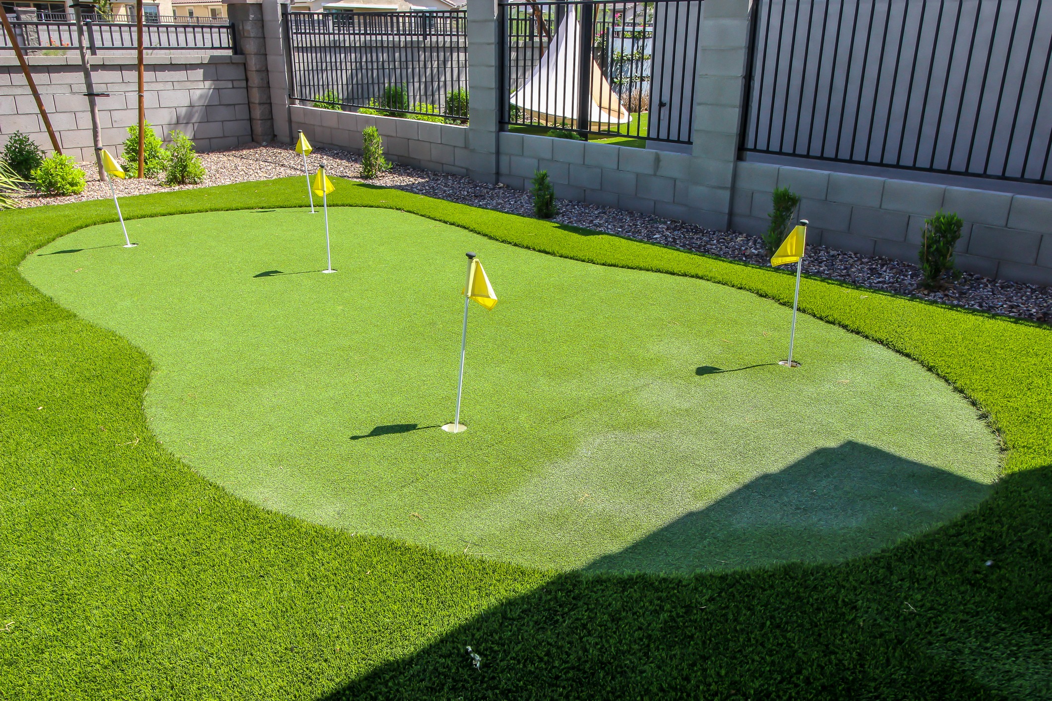 Backyard artificial turf putting green with flags