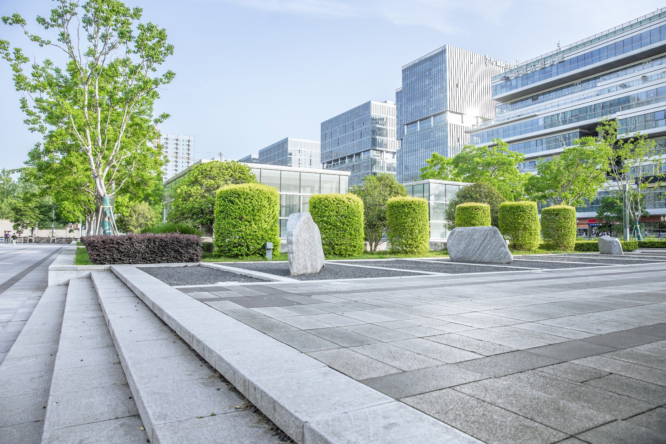 Modern urban plaza with landscaped greenery and offices