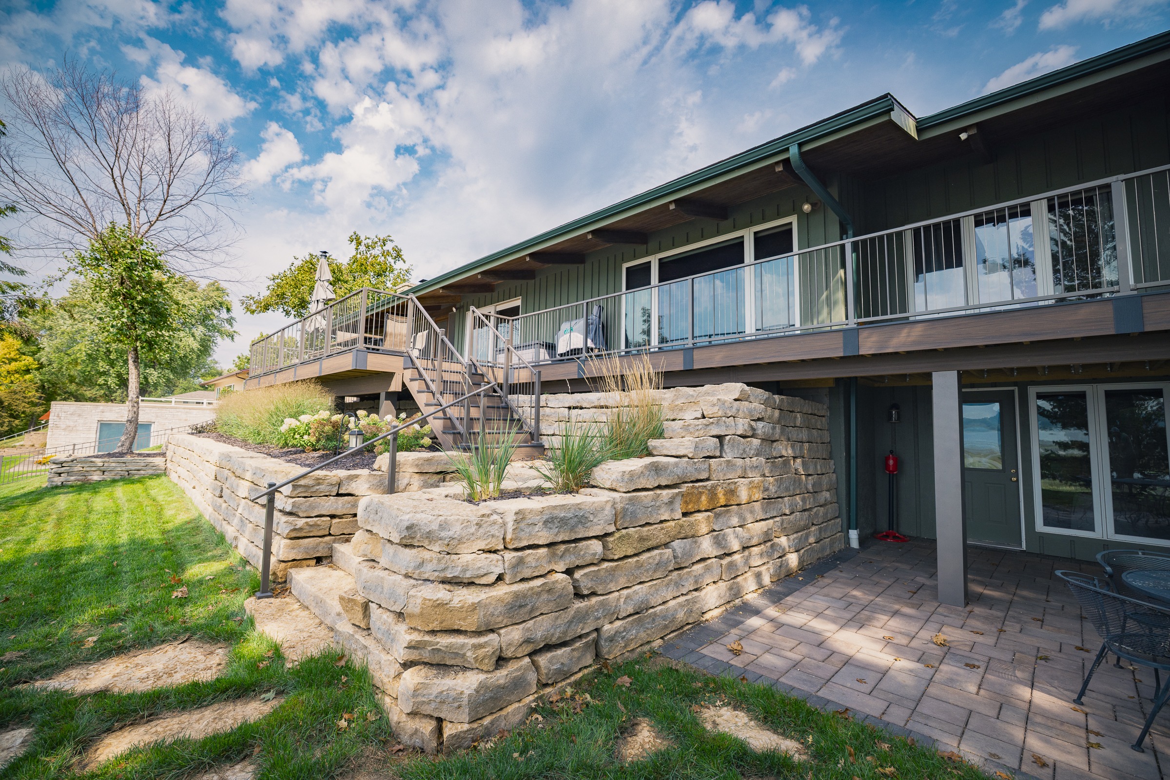 Modern home with elevated deck and stone retaining wall