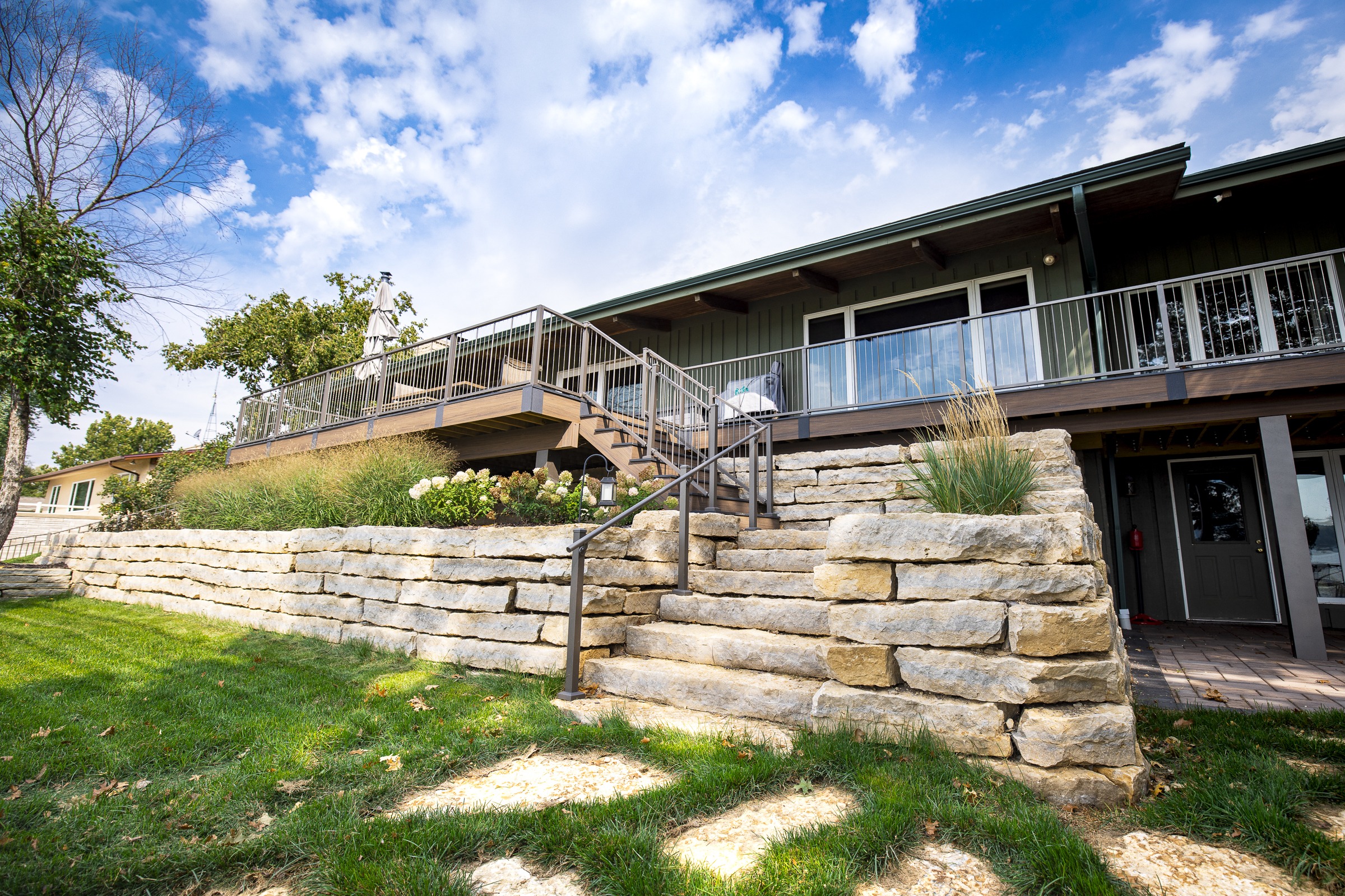 Modern home with elevated deck and stone retaining wall