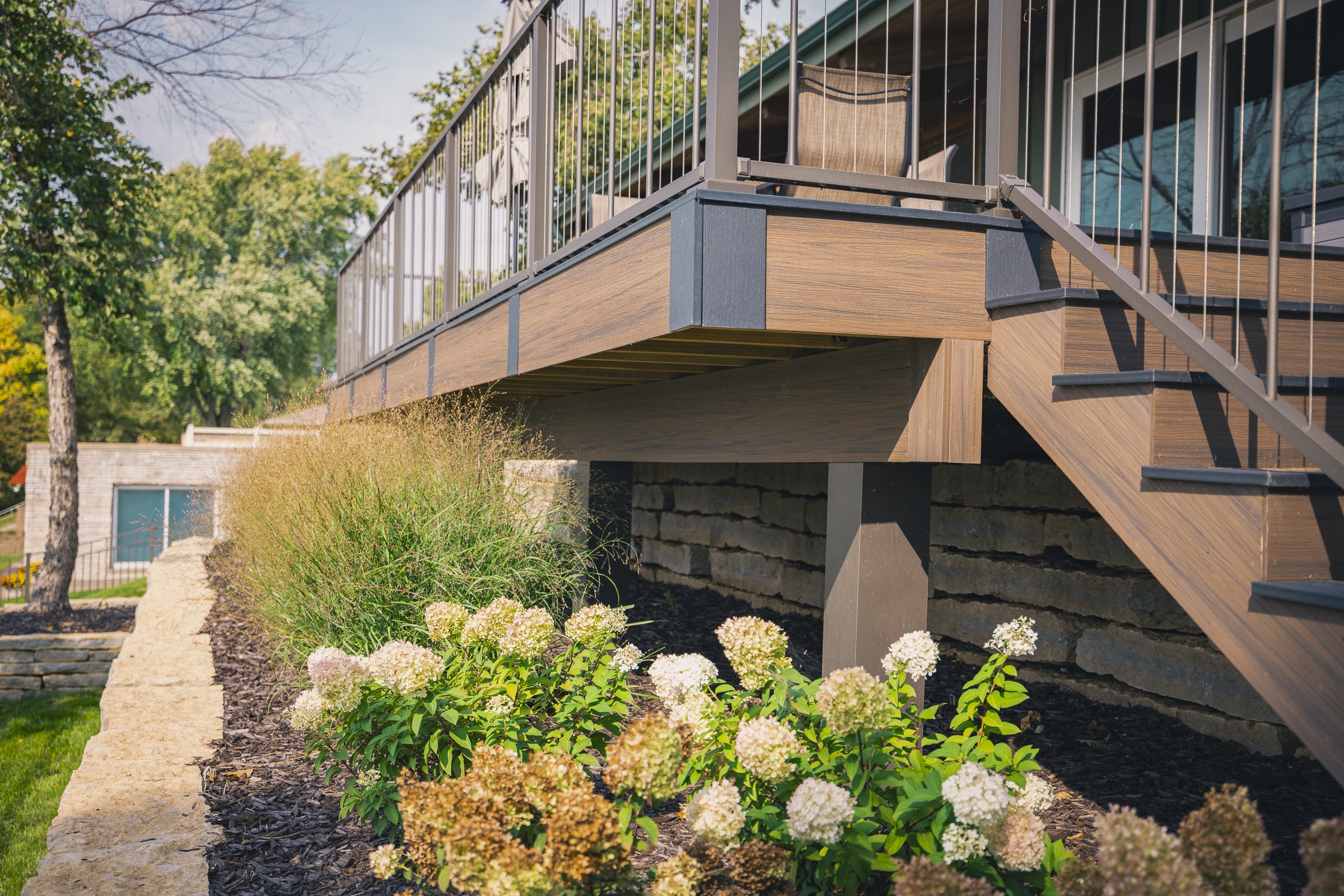 Elevated backyard deck with stairs and landscaped garden
