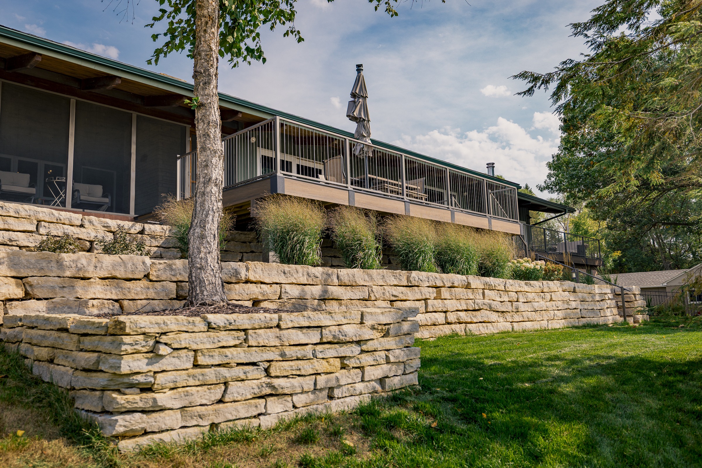 Modern home with elevated deck and stone retaining wall
