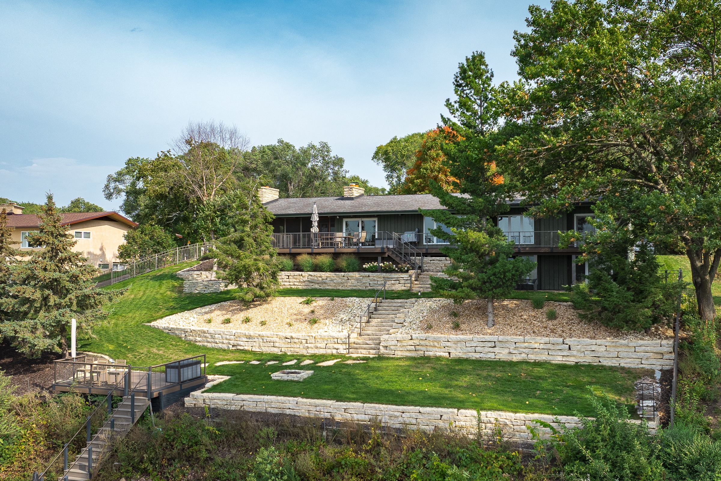 Hillside home with deck and terraced lawn