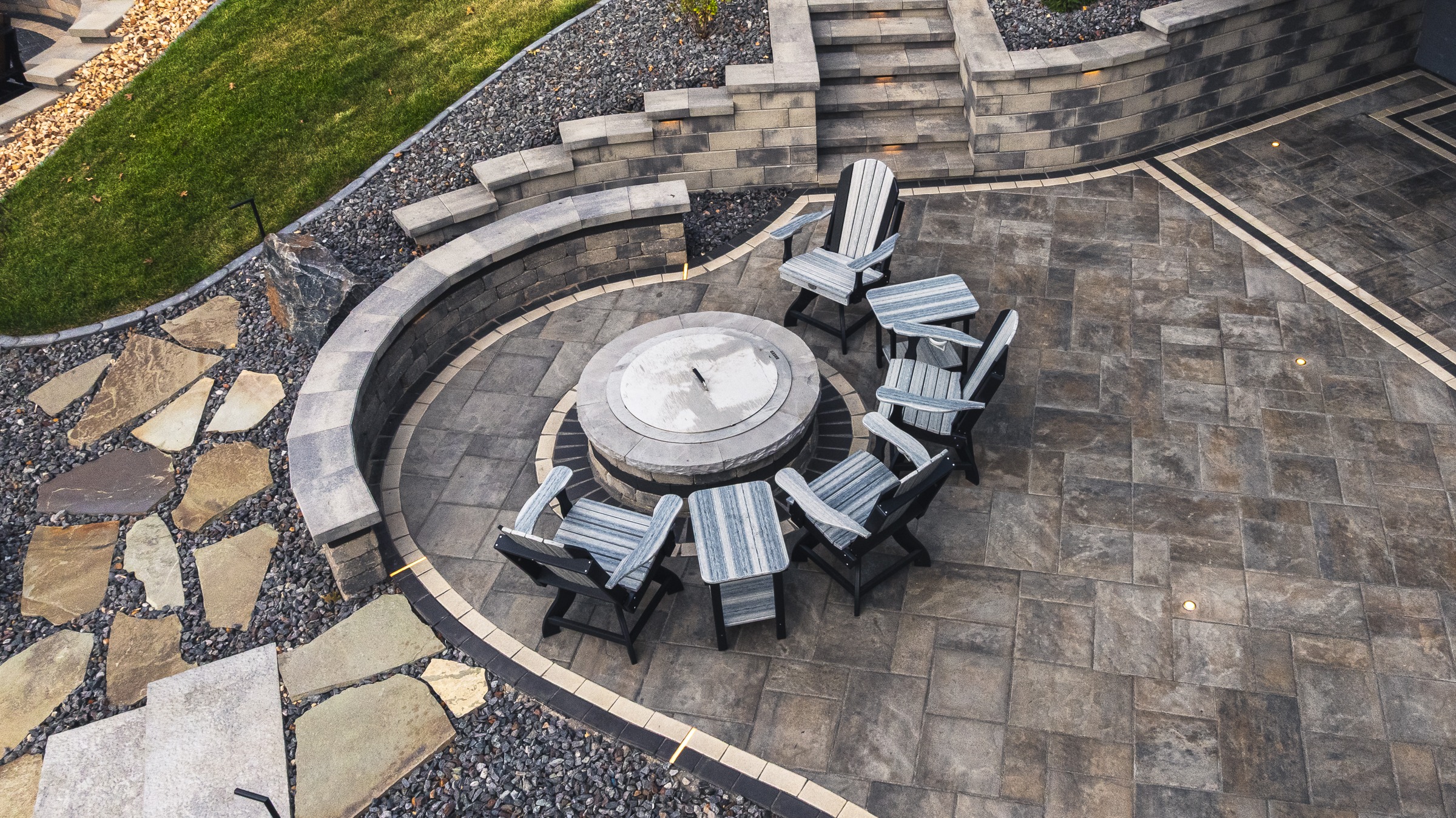 Circular patio with fire pit and Adirondack chairs