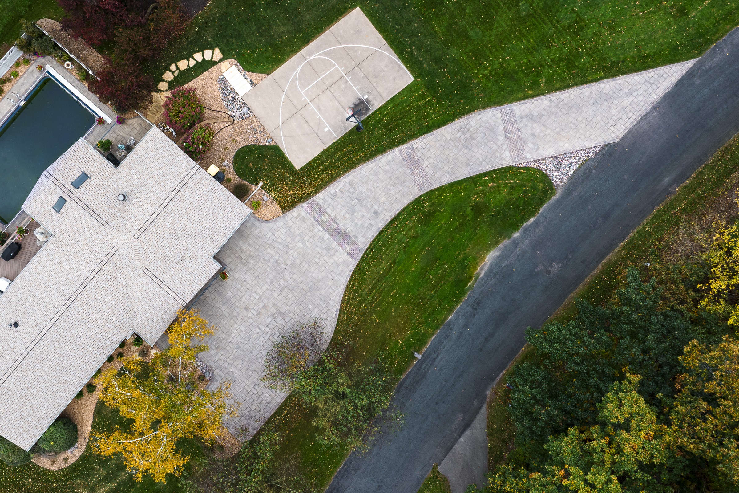 Aerial view of suburban home with driveway and court