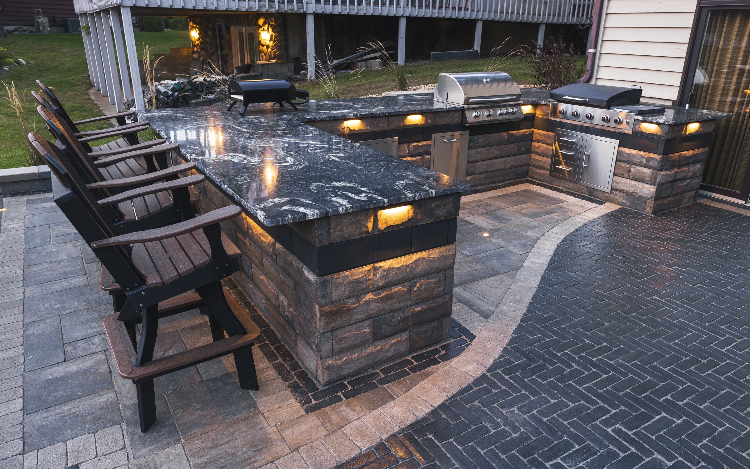 Outdoor stone kitchen with granite bar and grills