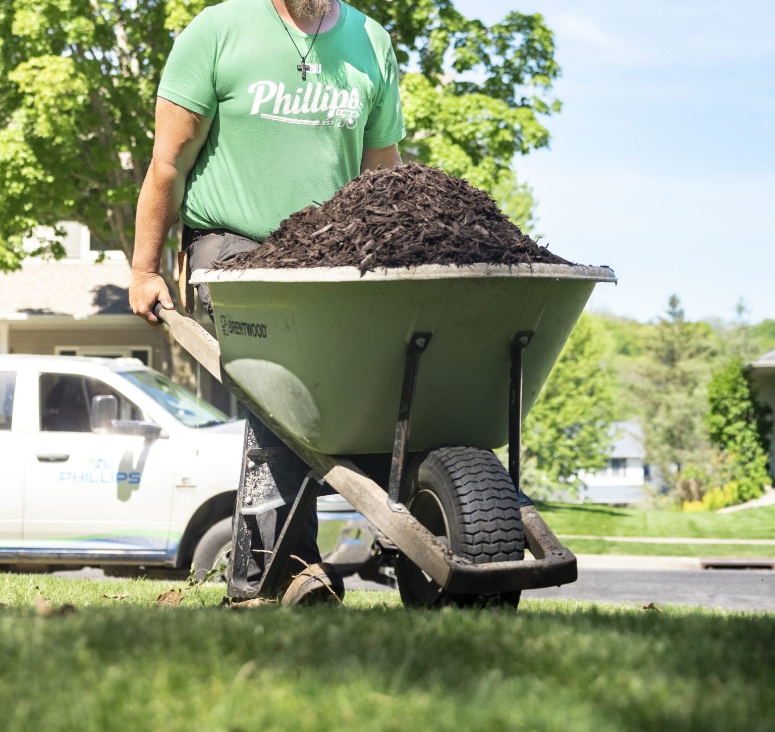 Landscaper pushing wheelbarrow full of mulch