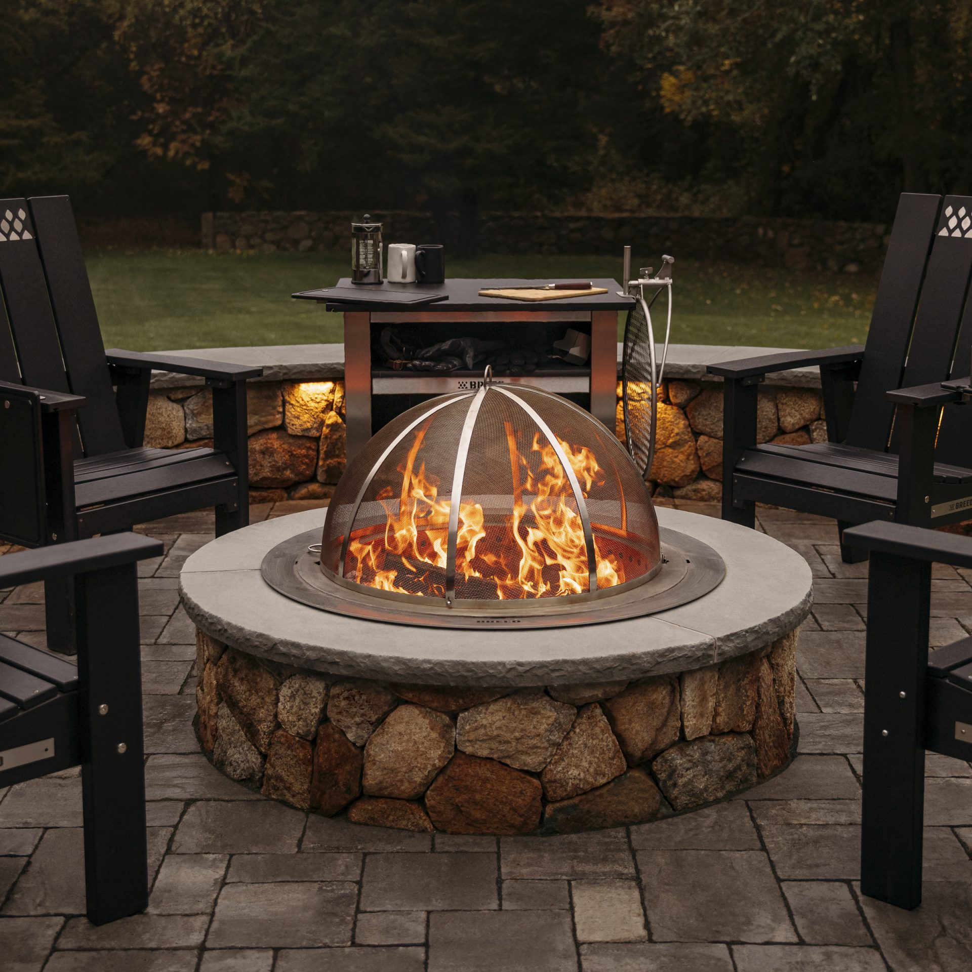 Breeo smokeless fire pit with chairs at dusk