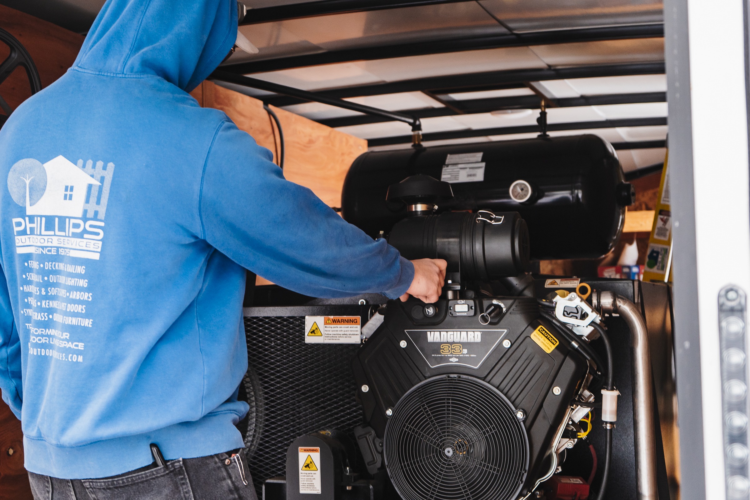 Worker servicing Vanguard engine inside trailer unit