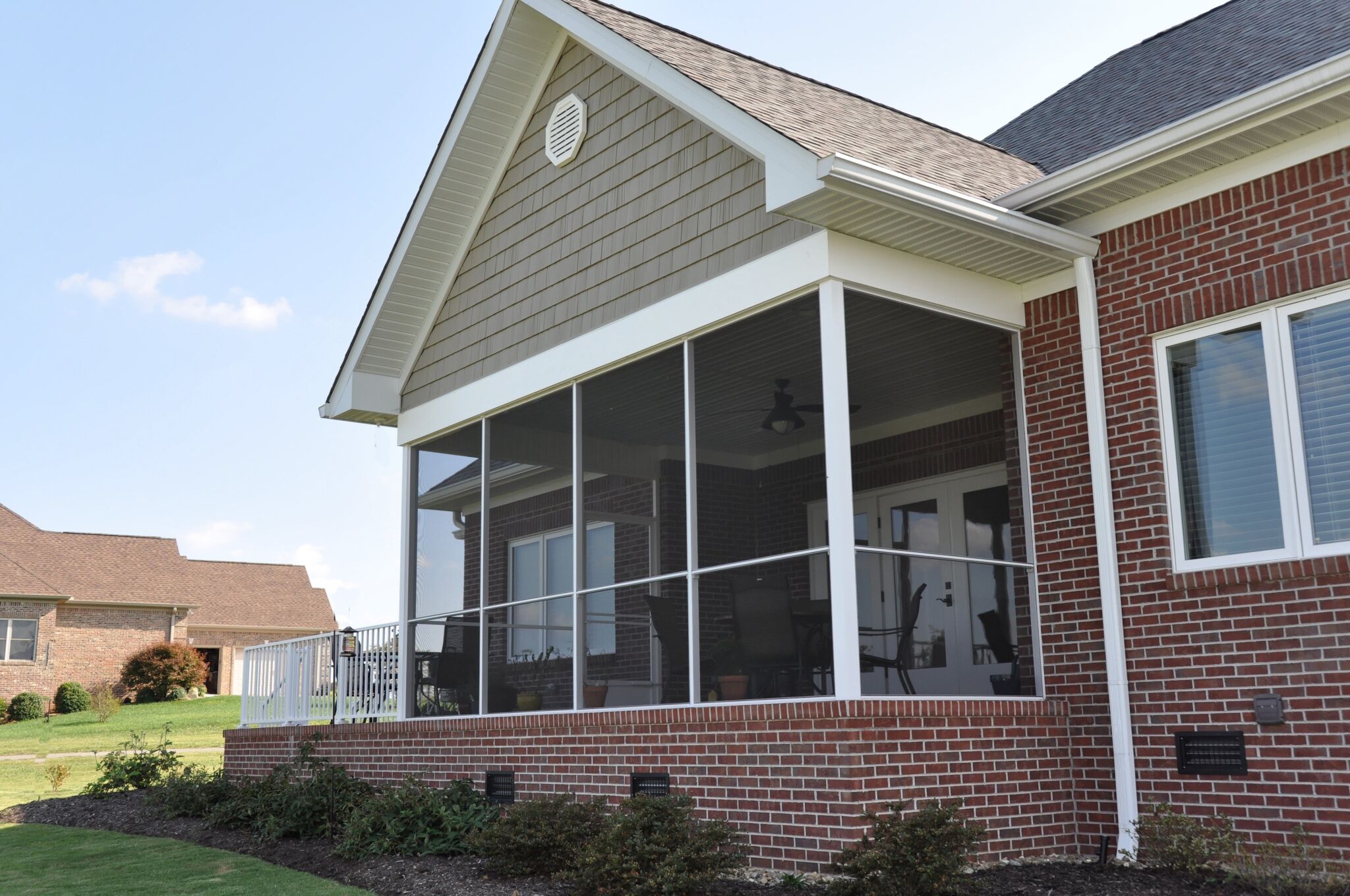 Brick house with Westbury screenrail installed on the backyard porch