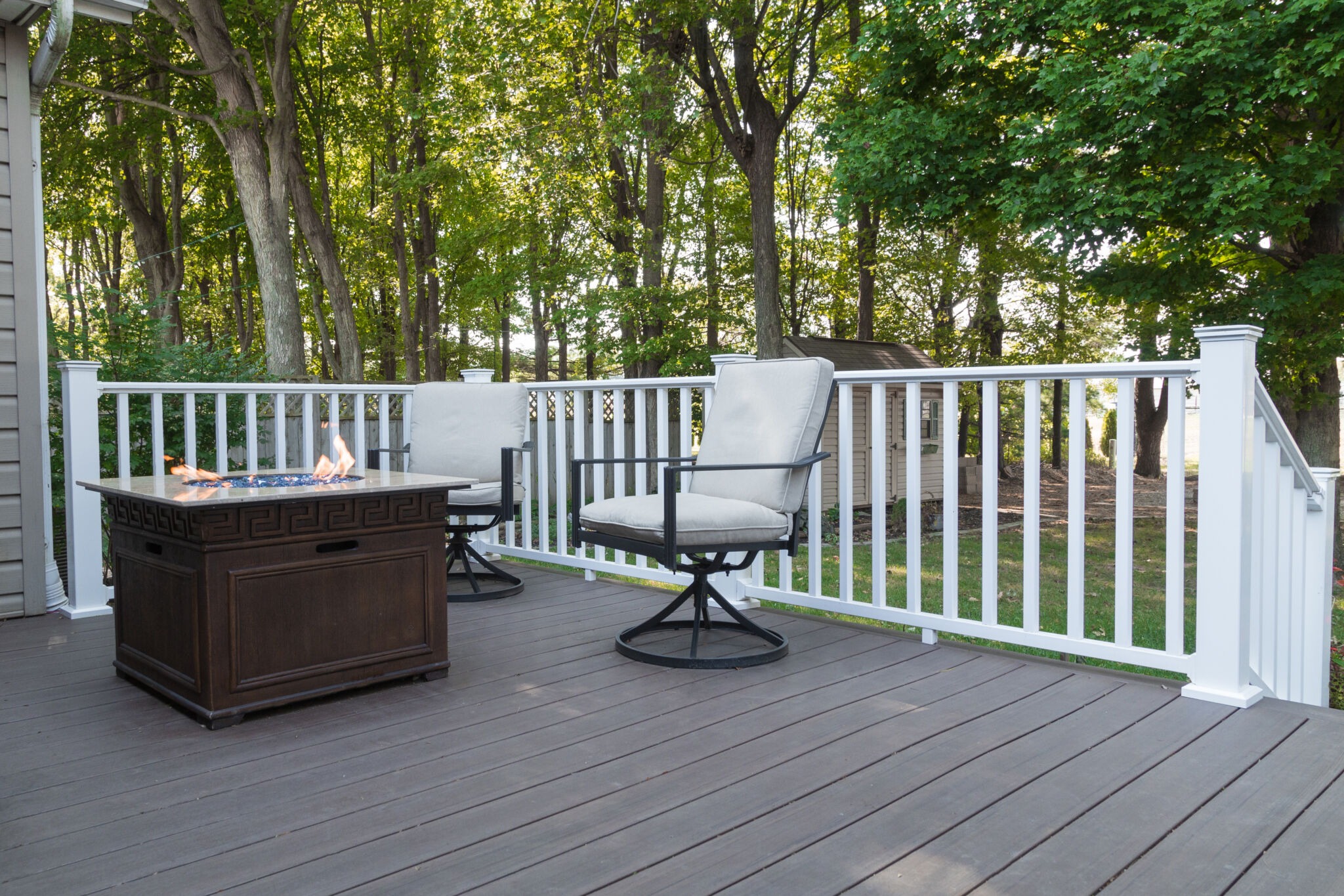 Backyard composite deck with Westbury TRX Vinyl Railing, chairs, and fire pit